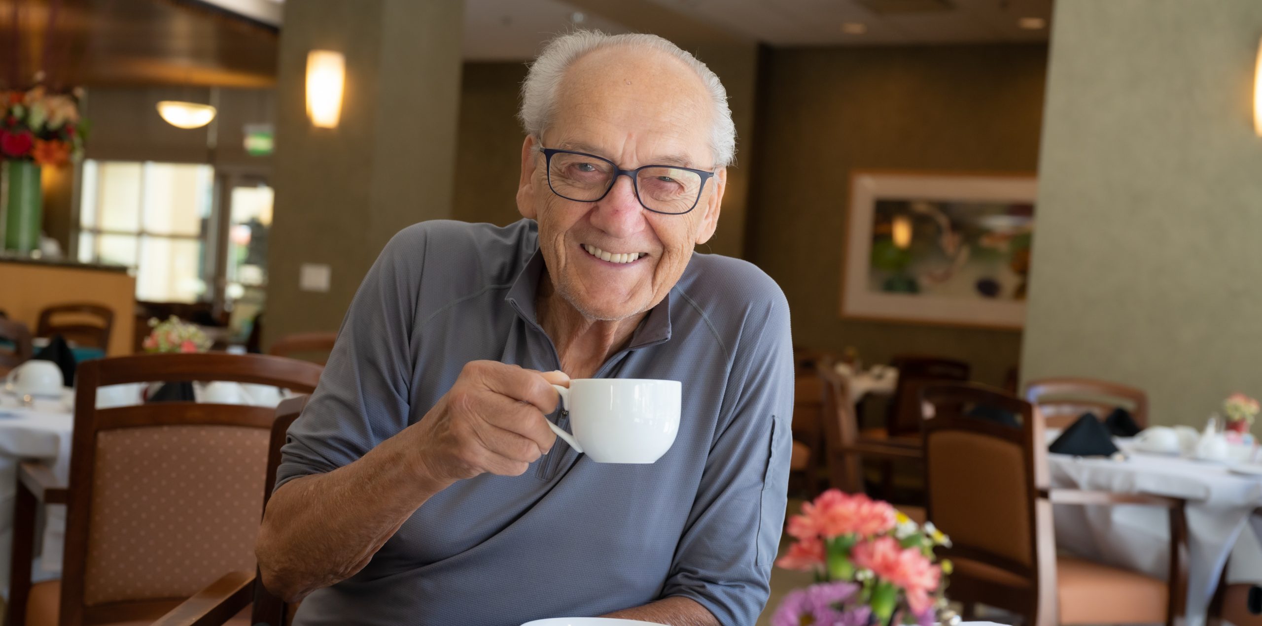 Man drinking coffee and looking at the camera
