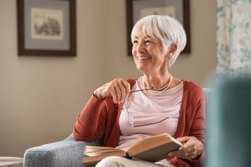 Happy mature woman wears a pink t-shirt reading 