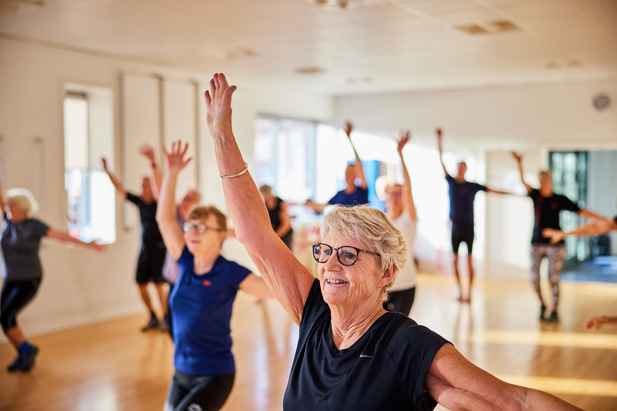 group of seniors doing yoga in a gym studio